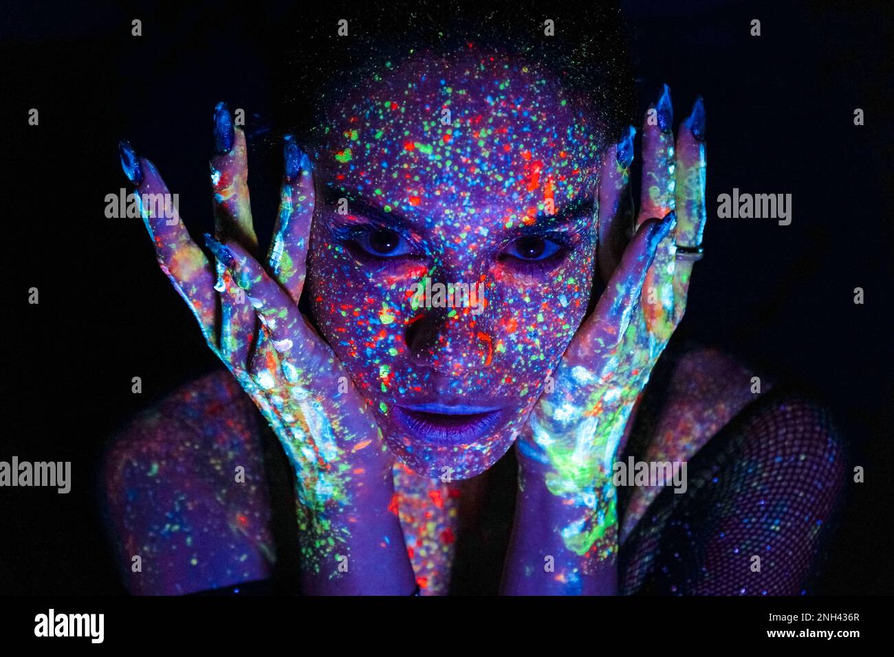 mesmerizing black female with fluorescent prints on skin, cosmic paint  glowing on neon lights, black background. young calm and peaceful lady  losing h Stock Photo - Alamy