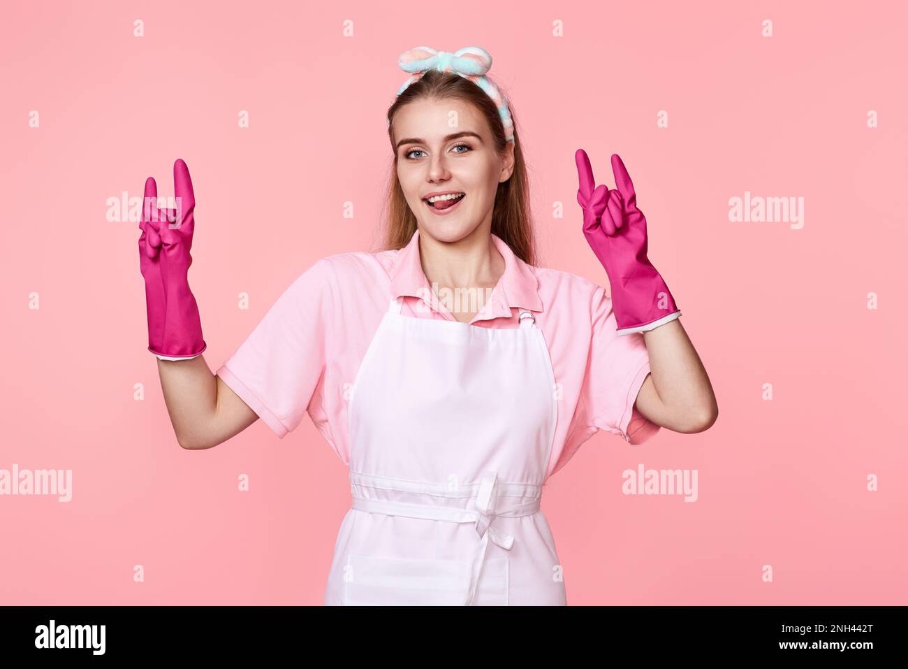 woman in rubber gloves and cleaner apron showing rock sign Stock Photo ...