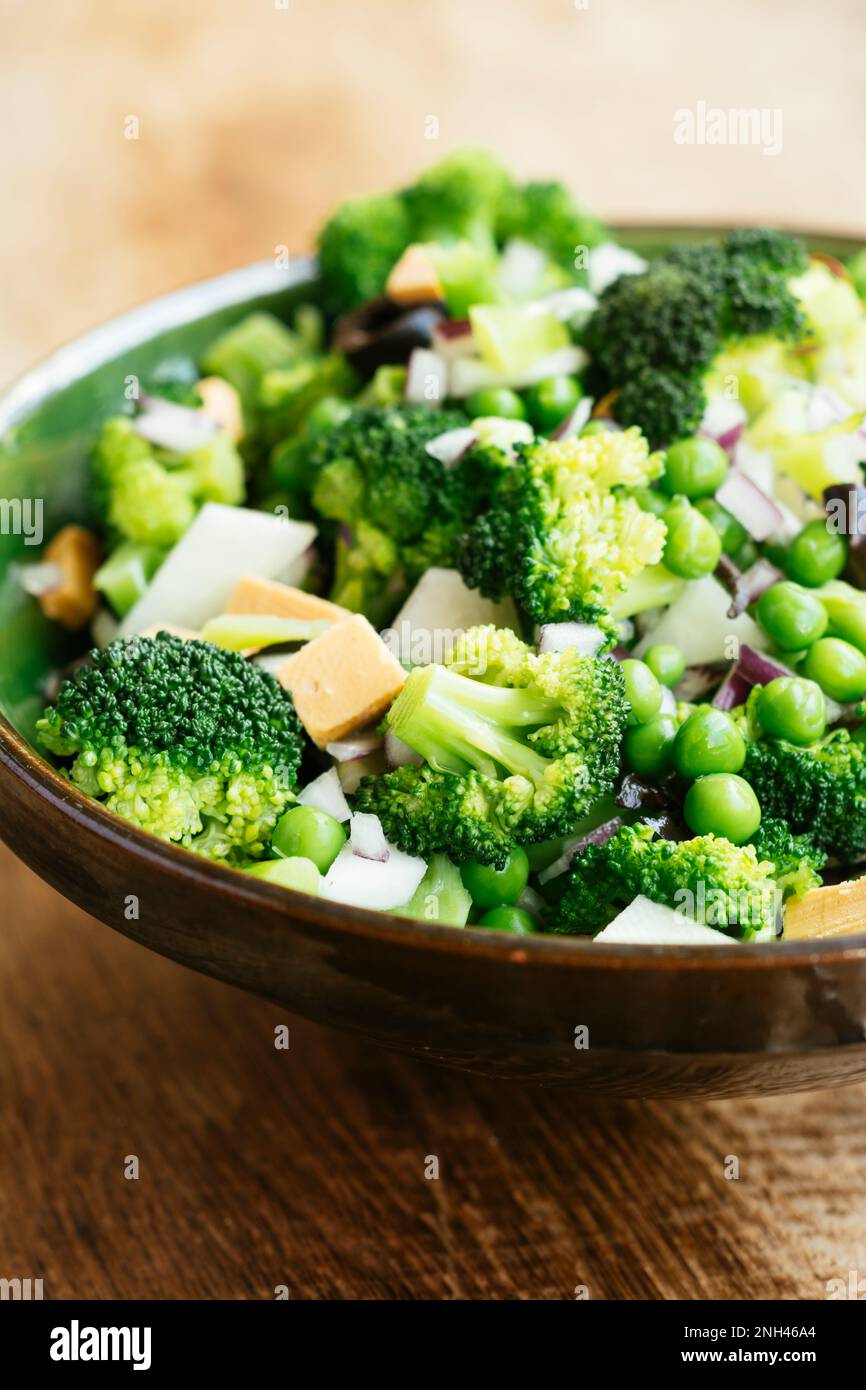 Fresh salad with broccoli, green peas, kohlrabi, red onion, black olives and vegan cheese Stock Photo