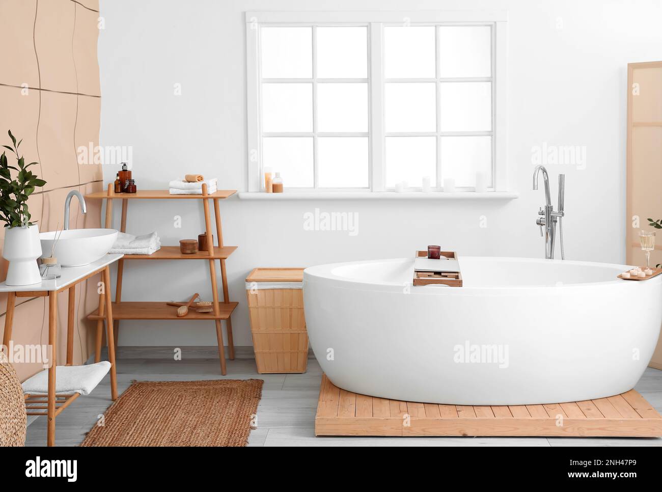 Modern bath room and spa center on the white tub wooden table. Candles and  magazine with vases with flowers. White background wall. - Album alb9821746