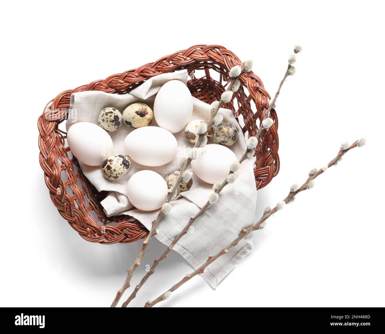 Wicker basket with Easter eggs and willow branches on white background ...