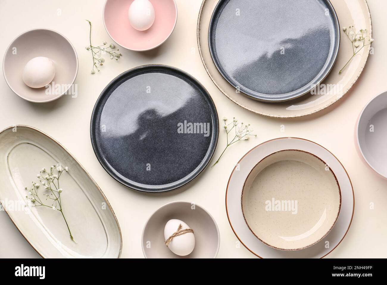 Composition with set of plates, Easter eggs and gypsophila flowers on ...