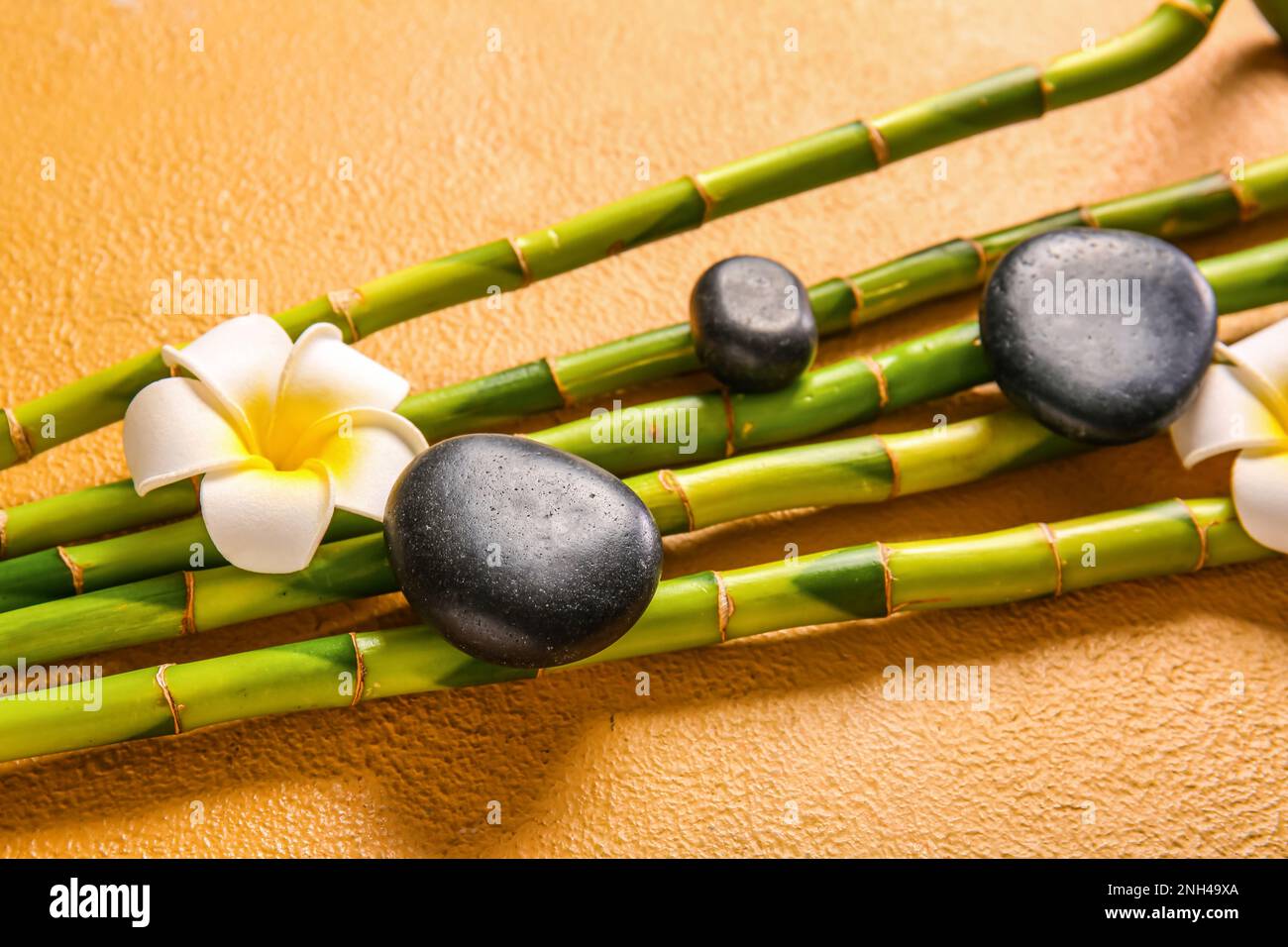 Spa stones, flower and bamboo on beige background Stock Photo - Alamy