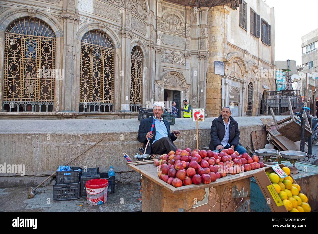 Egyptian man smoking shisha or hookah at a fruit stall, Old City, Cairo