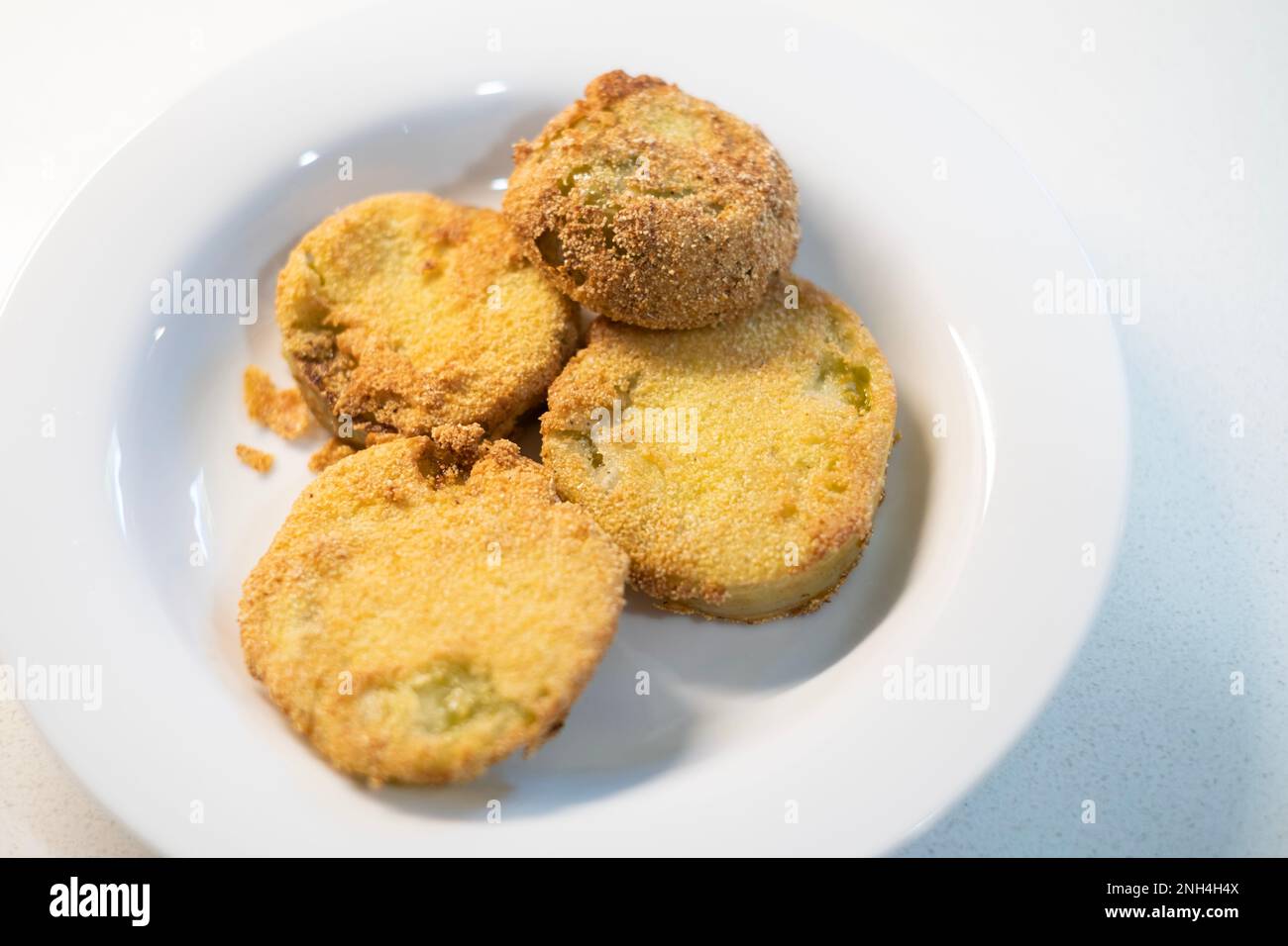 Fried green tomato slices, a way to use green tomatoes before they are lost due to a freeze. Kansas, USA. Stock Photo