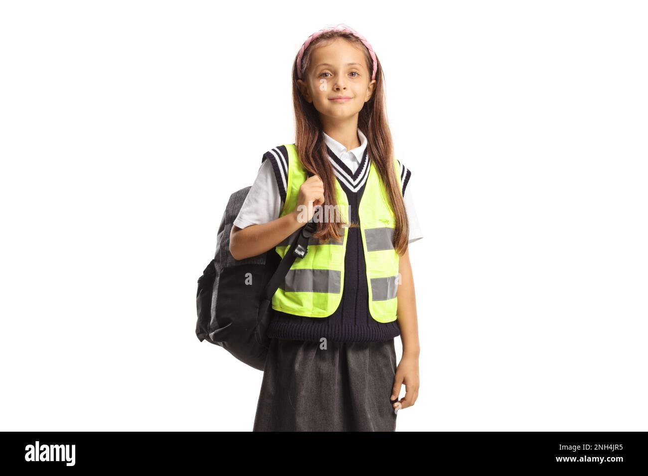 Schoolgirl with a backpack wearing a reflective safety vest isolated on white background Stock Photo