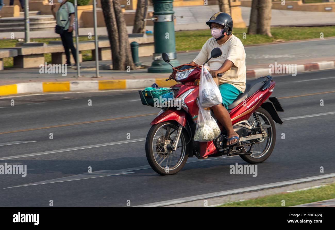 BANGKOK, THAILAND, FEB 04 2023, A man rides a motorcycle at city street
