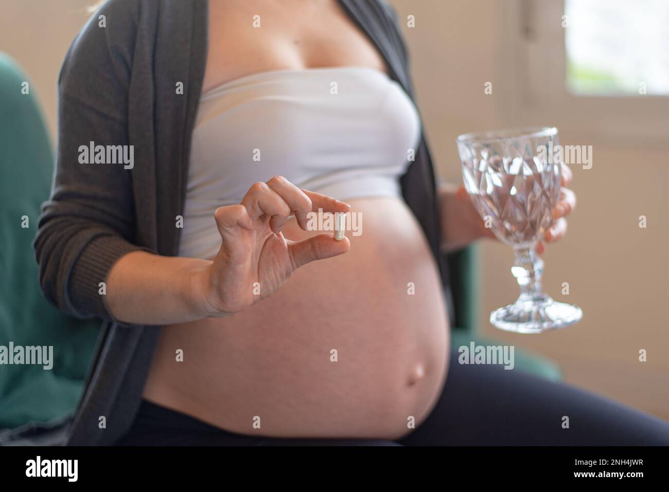 Pregnant woman taking compounded capsule Stock Photo