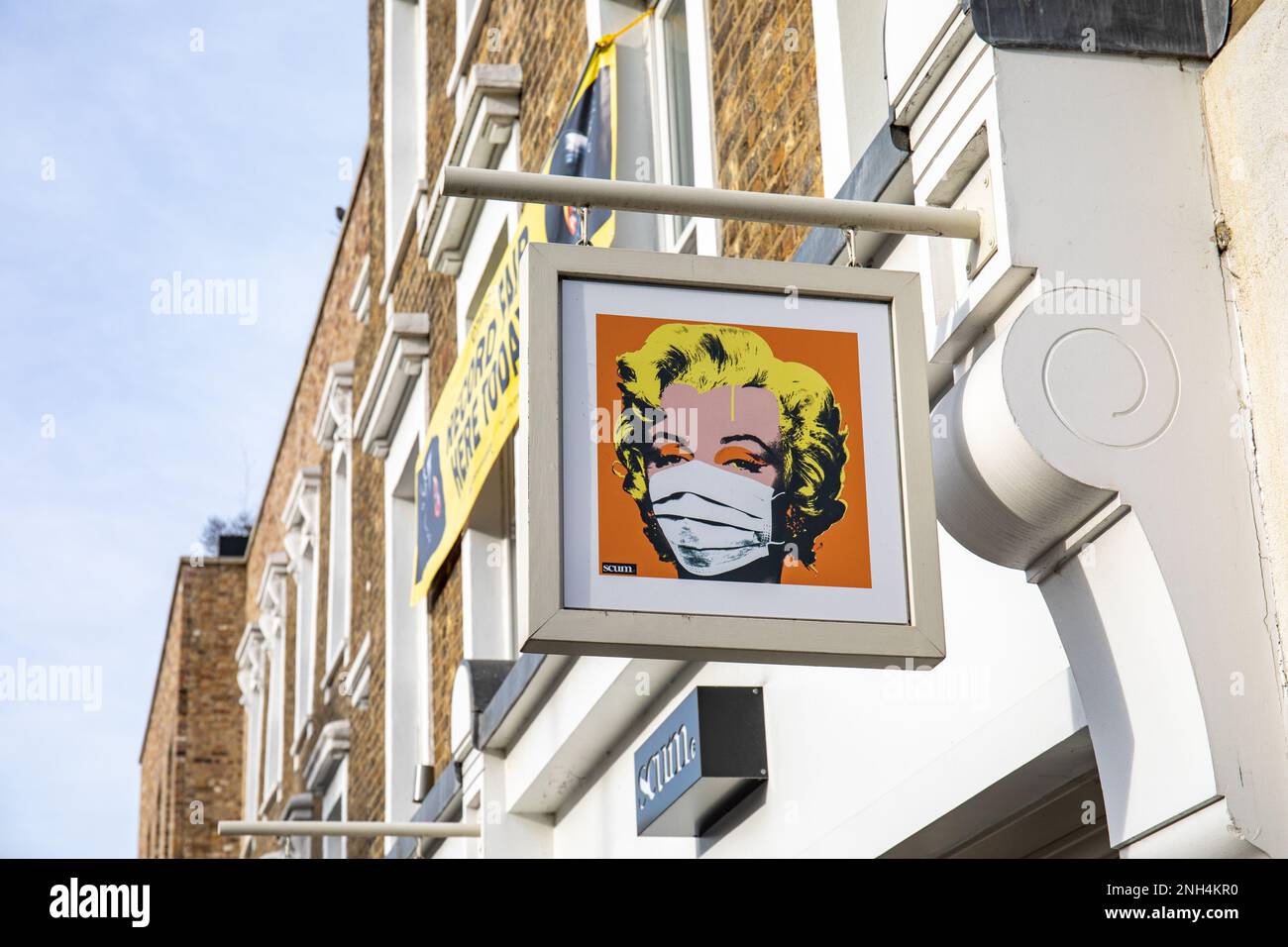 Marilyn Monroe wearing a face mask on Scum UK sign in Camden Town district of London, England Stock Photo