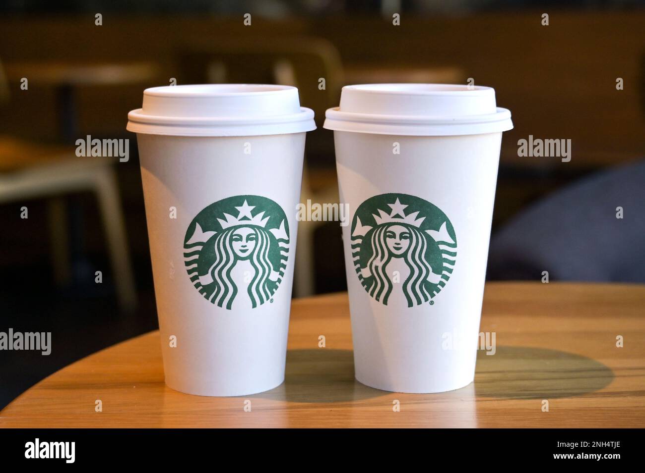 Austin, Texas - February 2023: Two paper cups with the Starbucks logo on a table in one of the company's chain of coffee shops Stock Photo