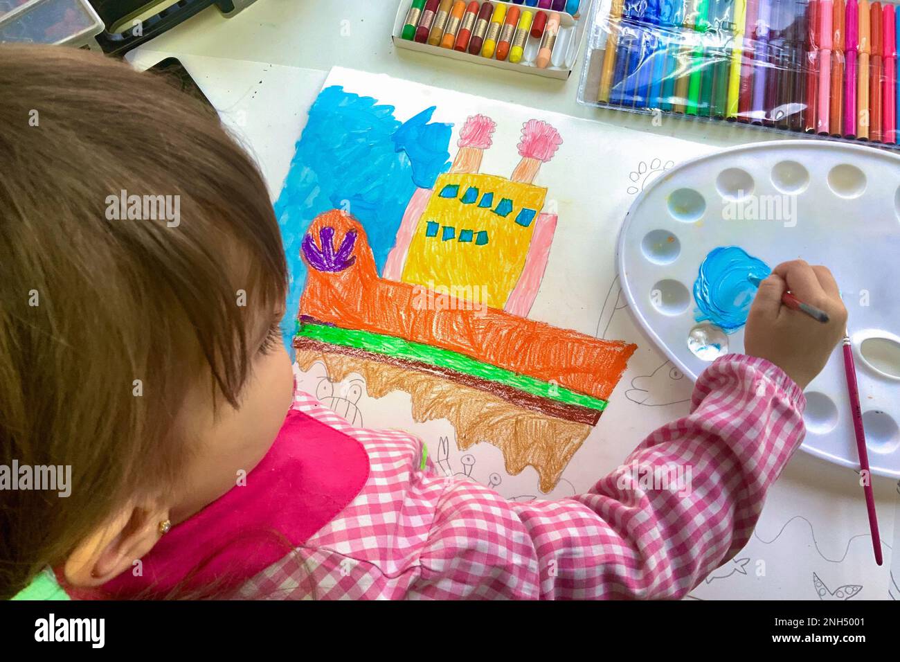 Young girl painting during art class at school Stock Photo