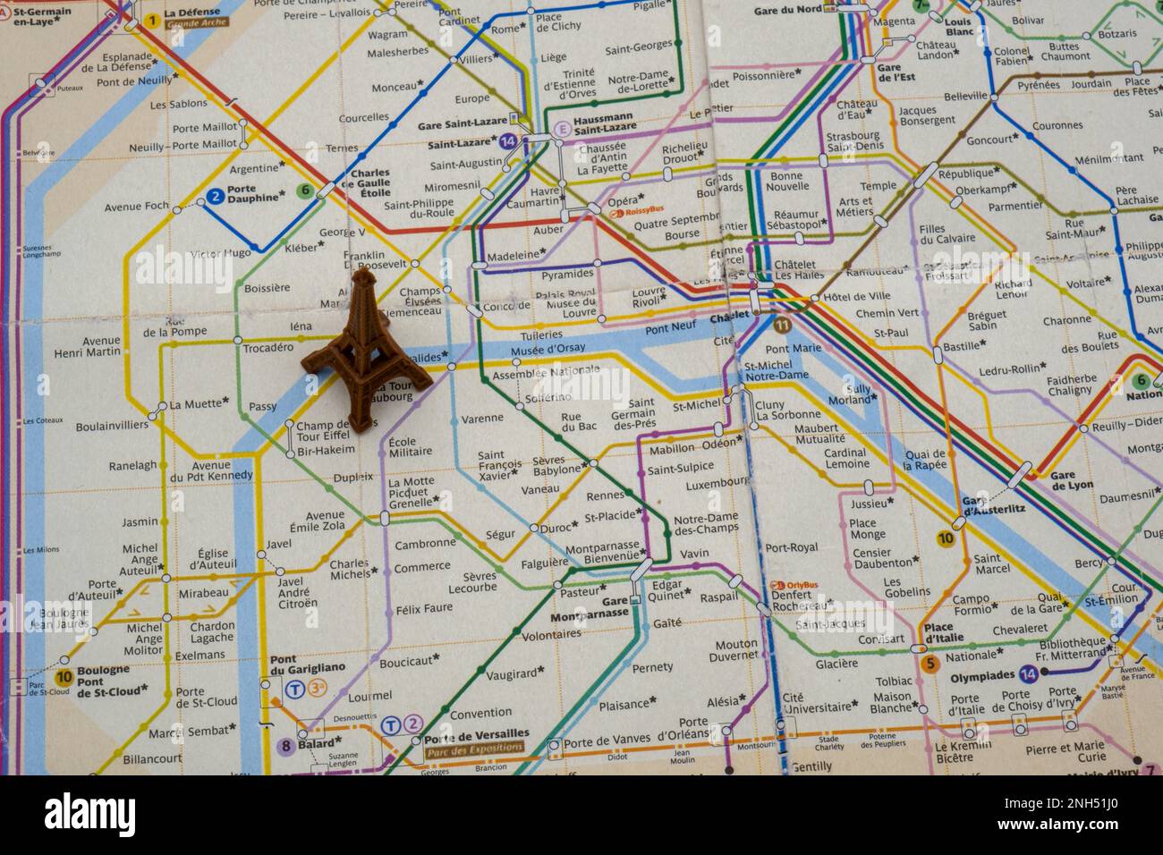 Close up top view of toy Eiffel tower on colorful Paris subway map