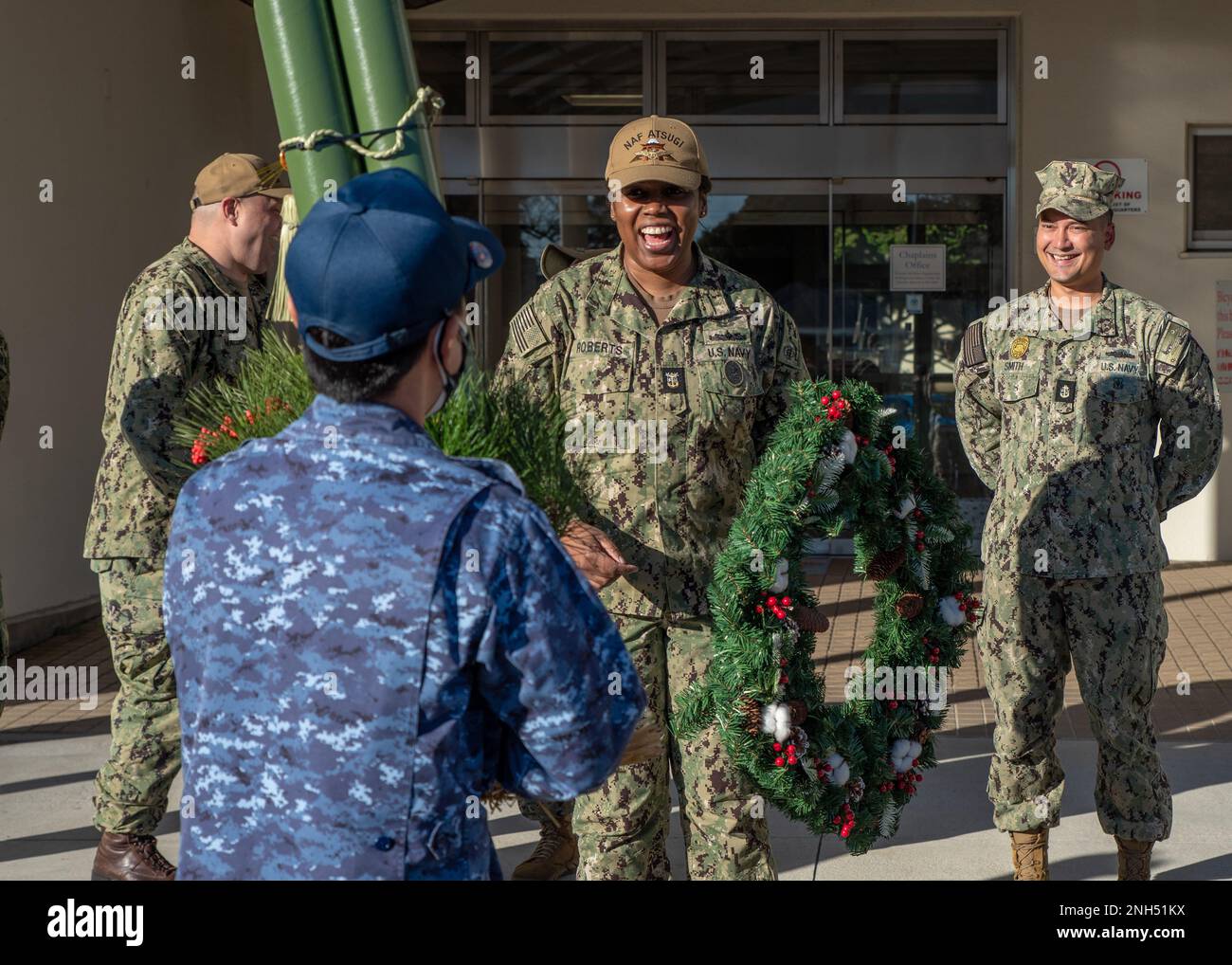 21214-N-VI040-1059 ATSUGI, Japan (Dec. 14, 2022) Command Master Chief Weba Roberts, command master chief, Naval Air Facility (NAF) Atsugi, presents a holiday wreath to the Japanese Maritime Self-Defense Force (JMSDF) Chiefs Mess during a cultural exchange ceremony at NAF Atsugi headquarters Dec. 14, 2022. The NAF Atsugi Chiefs Mess and JMSDF Chiefs Mess exchanged a wreath and Kadomatsu in celebration of U.S. and Japanese holiday season traditions. The Kadomatsu is decoration made up of cut pine and bamboo that adorns the entrance of Japanese buildings during the New Year's season. Stock Photo