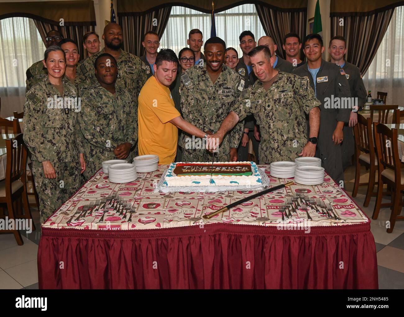 220621-N-GK686-1016 NAVAL AIR STATION SIGONELLA, Italy (June 21, 2022)  Cmdr. Ronald Cappellini, Naval Air Station Sigonella executive officer,  cuts a cake with Ristorante Bella Etna galley patrons in honor of  Juneteenth on