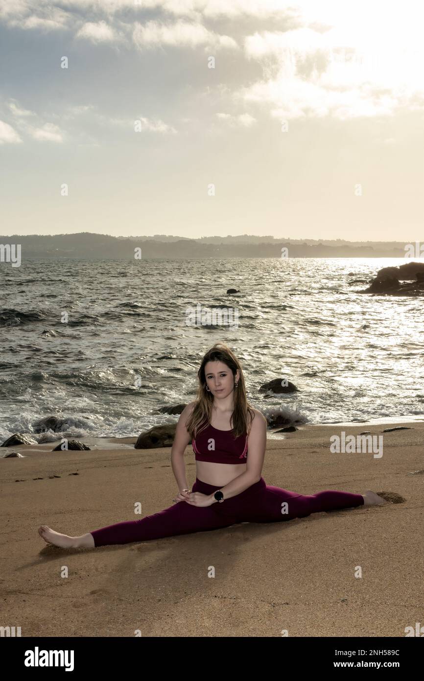 young woman doing the splits on the beach in front of the sea Stock Photo Alamy