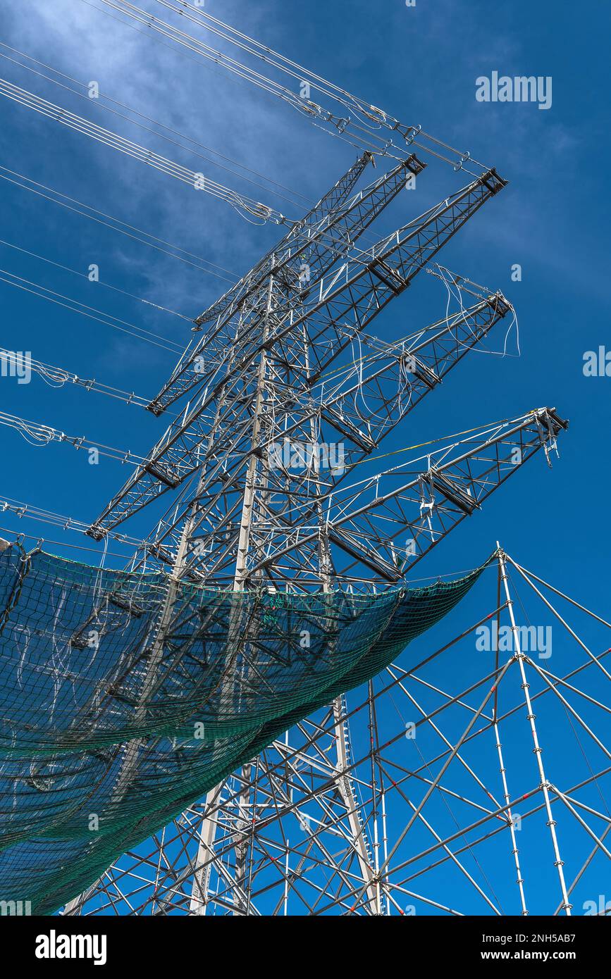 A newly installed high-voltage pylon with some cables connected Stock Photo