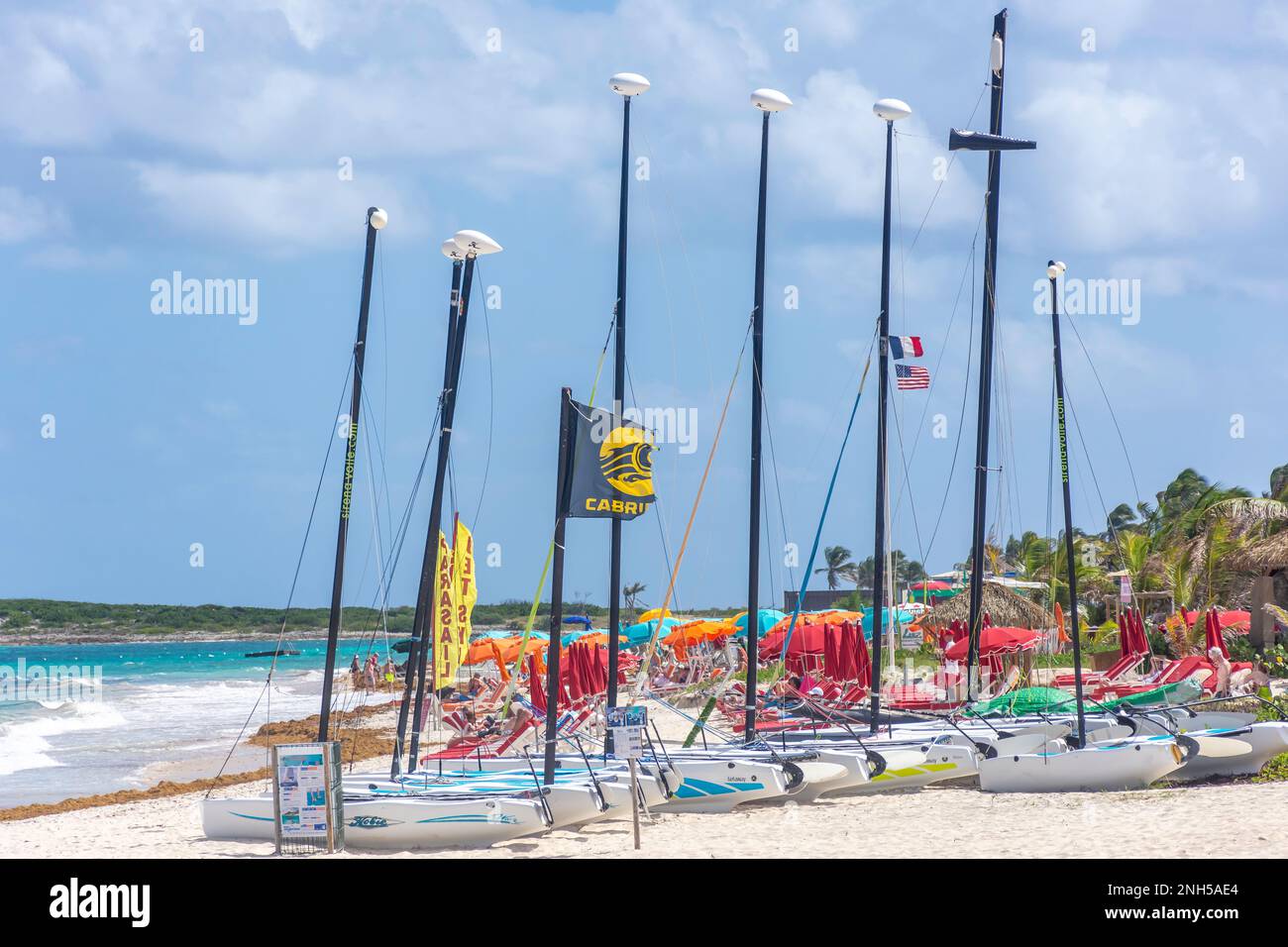 Catamaran boats and parasols on beach, Orient Bay (Baie Orientale), St Martin (Saint-Martin), Lesser Antilles, Caribbean Stock Photo