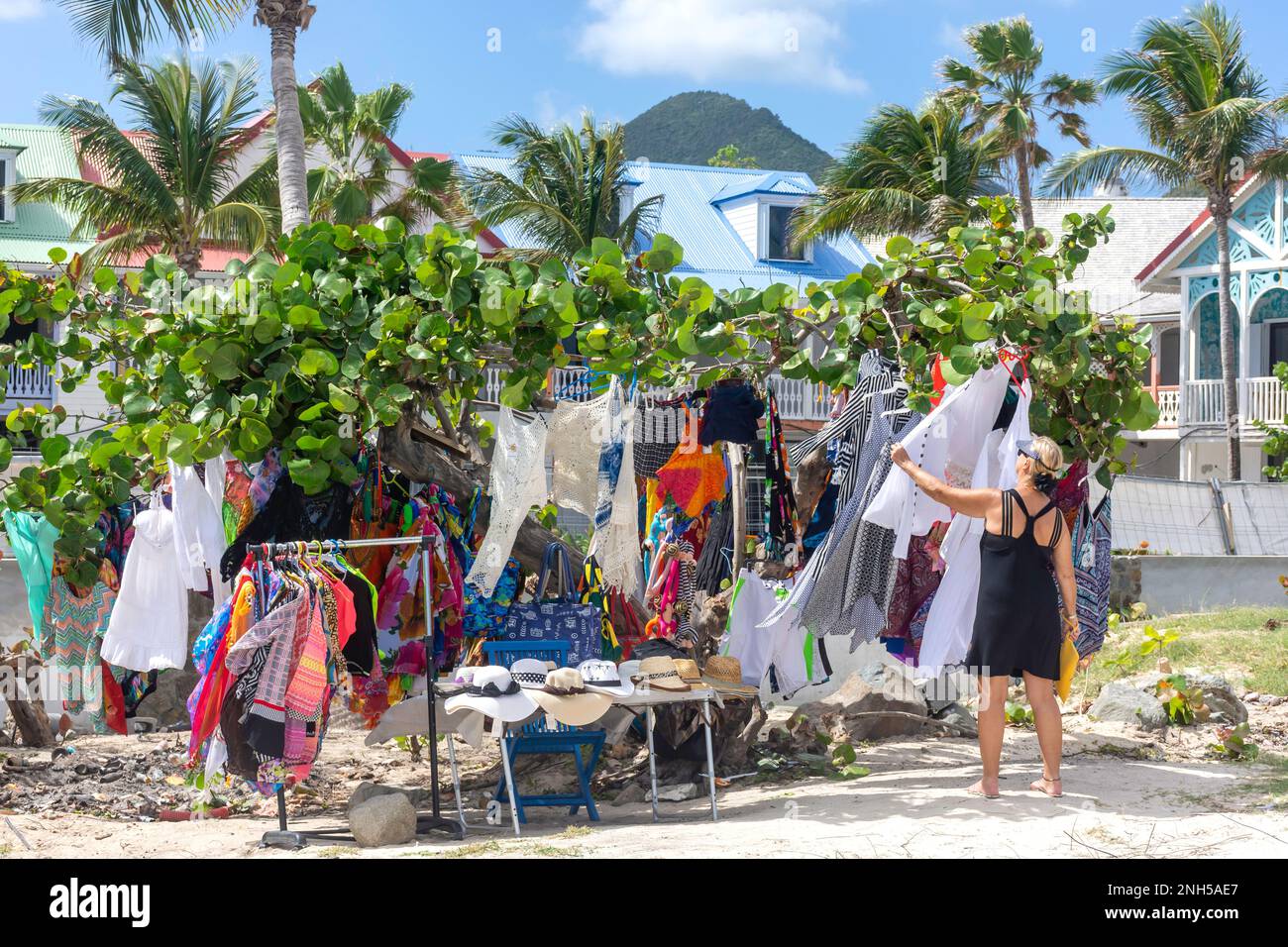 Woman looking at clothing stall by beach, Orient Bay (Baie Orientale), St Martin (Saint-Martin), Lesser Antilles, Caribbean Stock Photo