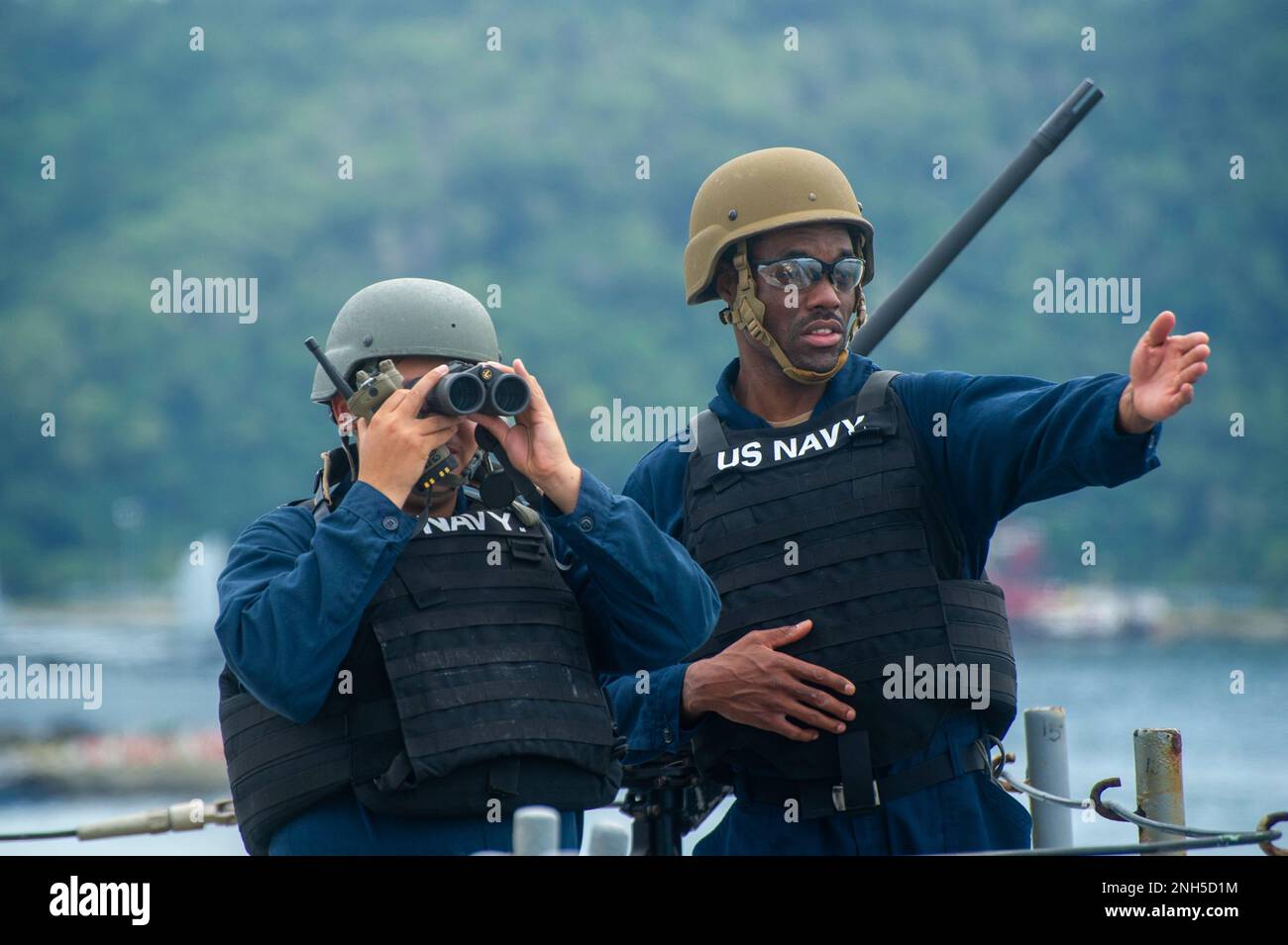 KOTA KINABALU, Malaysia (July 17, 2022) Gunner’s Mate 3rd Class Jonathan Marmolejo (left), from Los Angeles, and Torpedoman’s Mate 1st Class Mikal Magee (right), from Waycross, Georgia, both assigned to the Emory S. Land-class submarine tender USS Frank Cable (AS 40), stand watch as the ship departs from Sepanggar Naval Base in Kota Kinabalu, Malaysia, July 17, 2022. Frank Cable is currently on patrol conducting expeditionary maintenance and logistics in support of a free Indo-Pacific in the U.S. 7th Fleet area of operations. Stock Photo