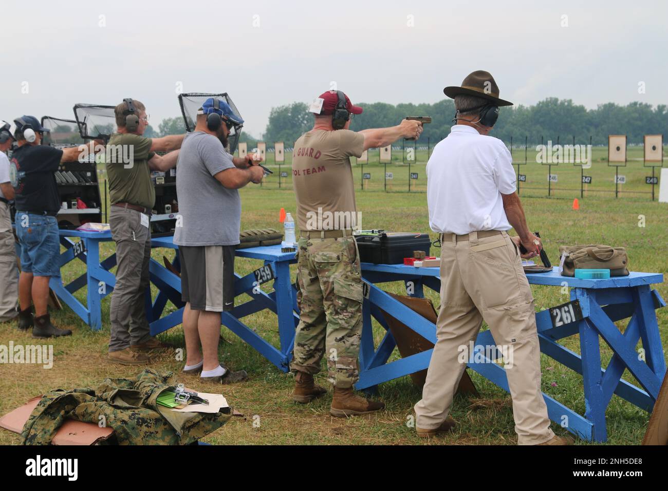 Competitors fire at their targets during the military and police pistol