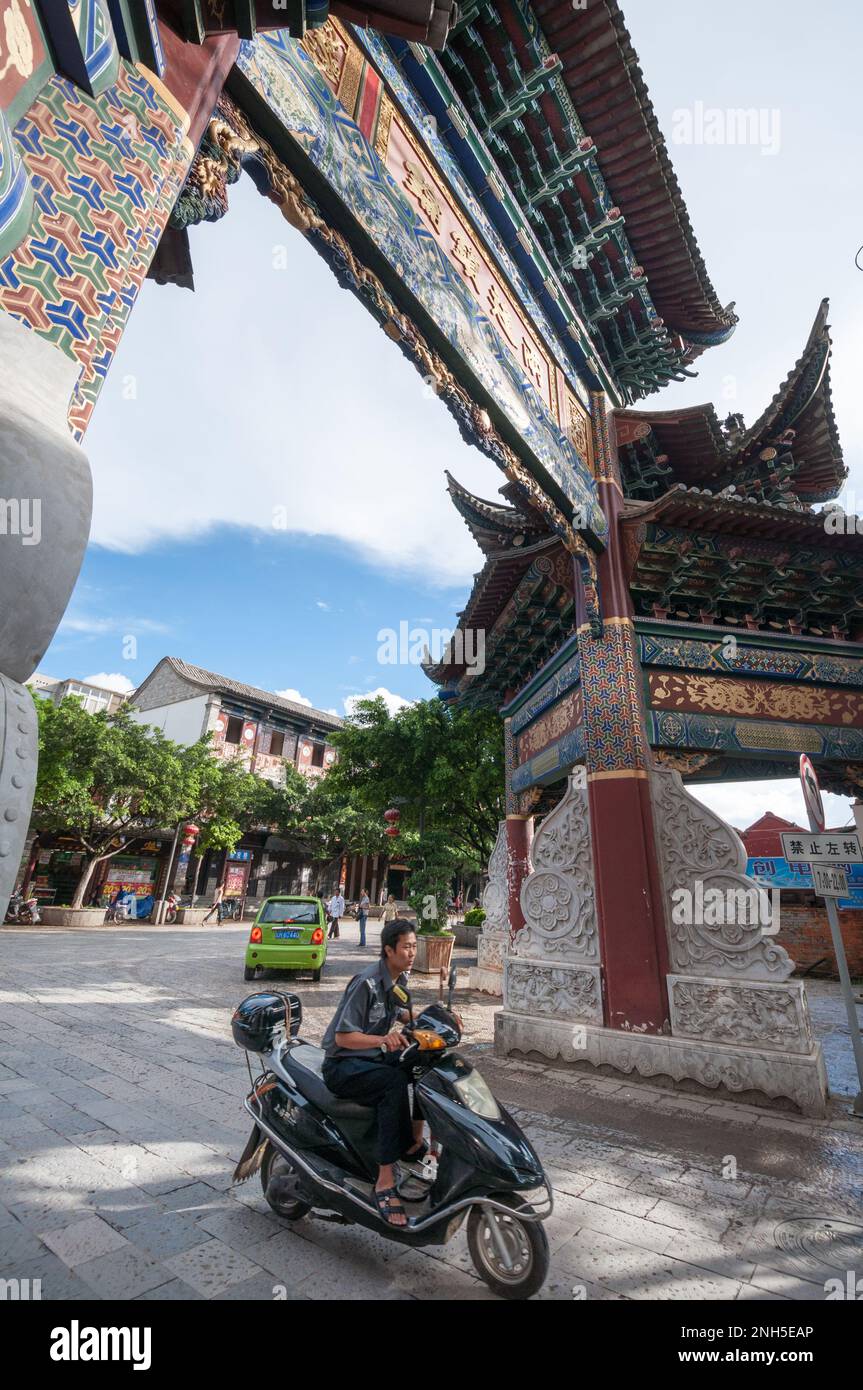A motorcyclist passes through a traditional gate in the Chinese city of Jianshui in Yunnan province Stock Photo