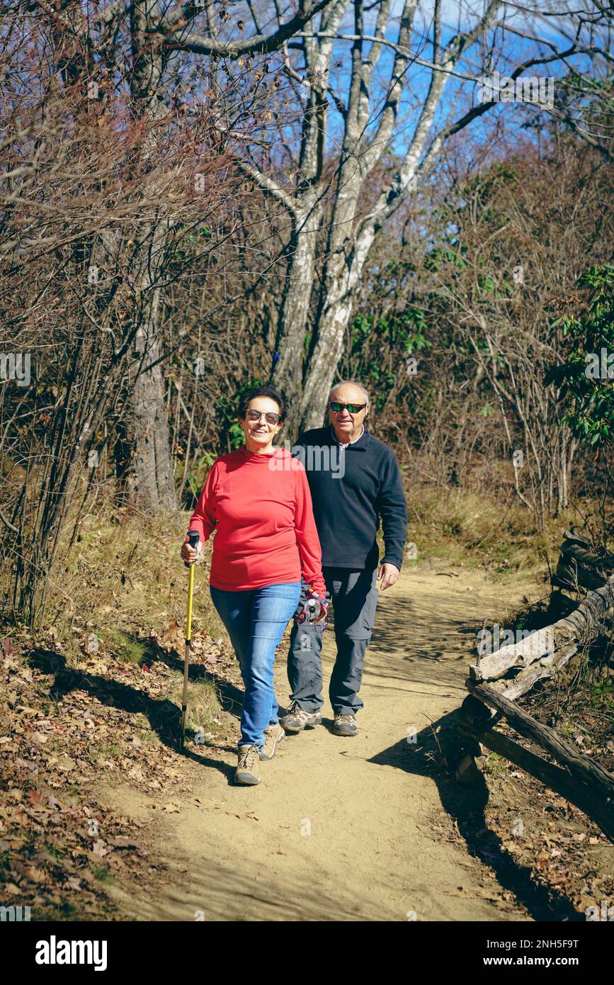 Senior couple is hiking in the woods in North Carolina in fall Stock Photo