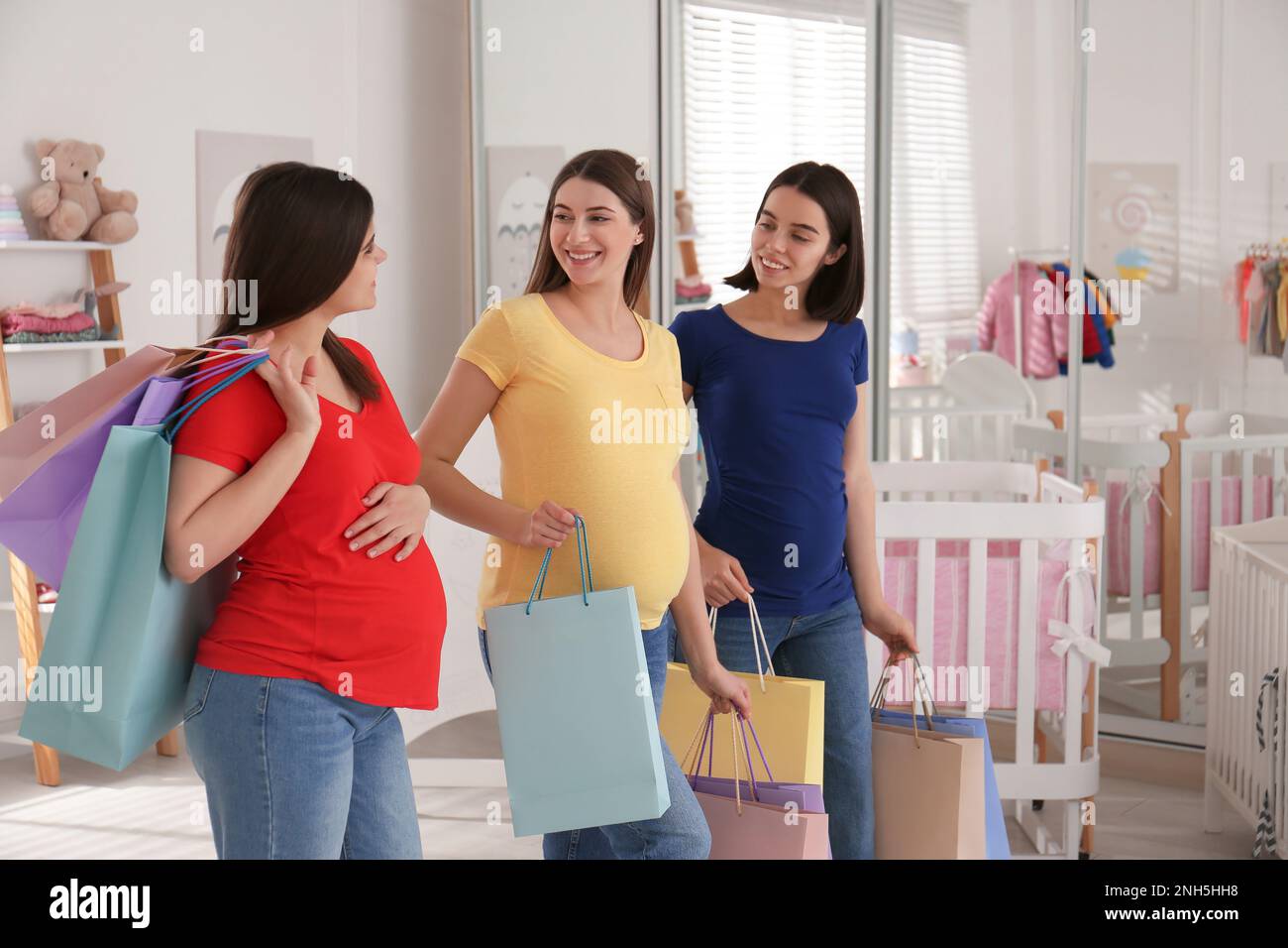 Happy pregnant women with shopping bags in store Stock Photo Alamy