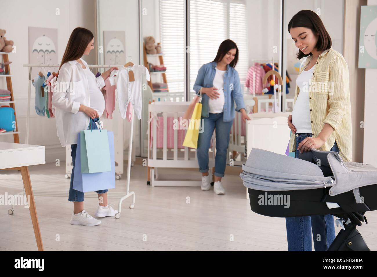 Happy pregnant women with shopping bags in store Stock Photo Alamy