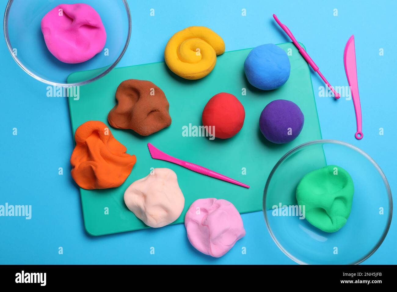 Flat lay composition with colorful plasticine on light blue background Stock Photo