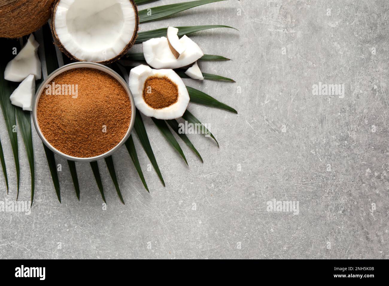 Flat lay composition with natural coconut sugar on grey table, space ...