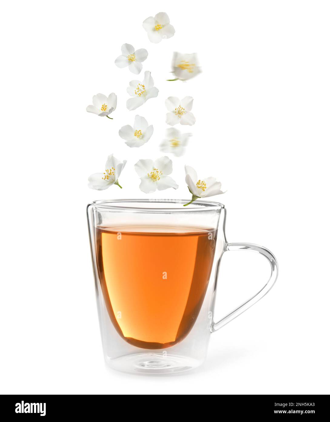 Beautiful jasmine flowers falling into cup of hot freshly brewed tea on