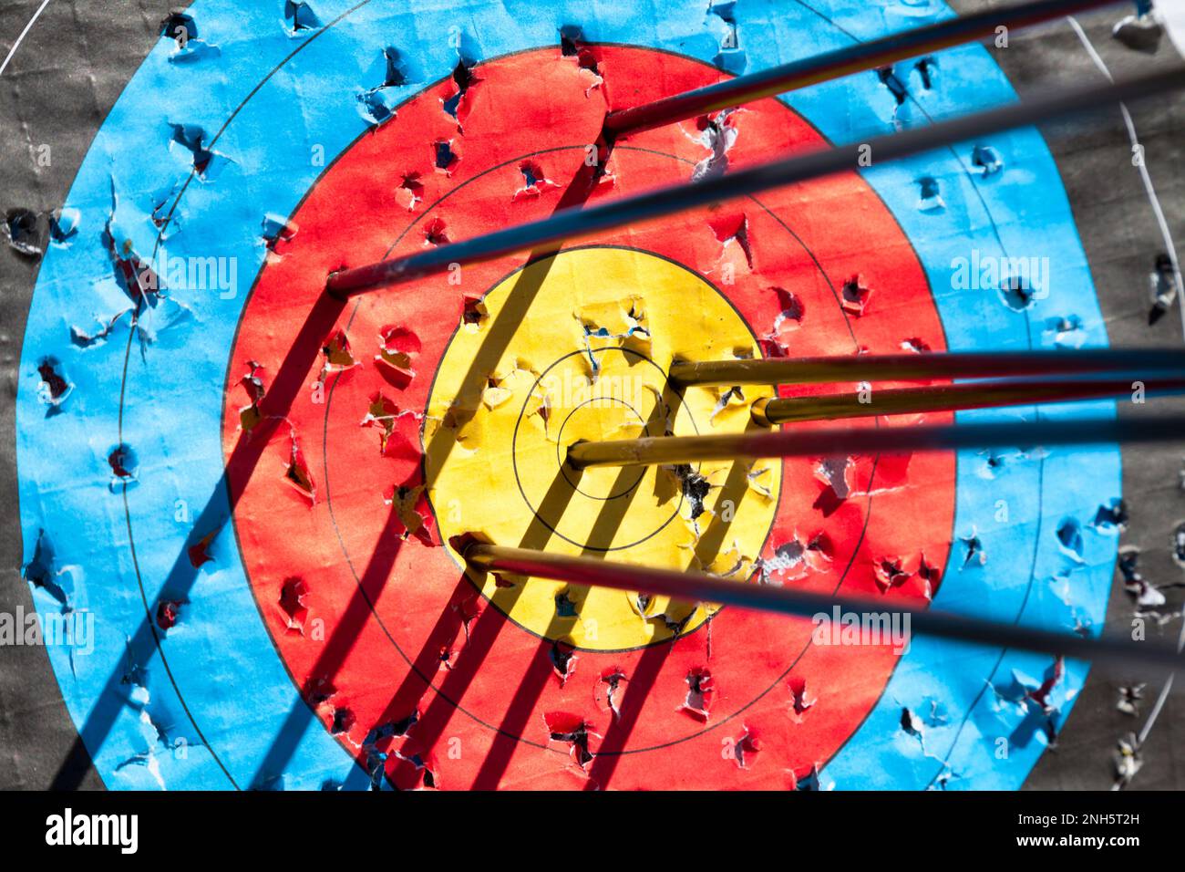 One out of six arrows in the bull'seye of an archery target. Selective focus with the focus