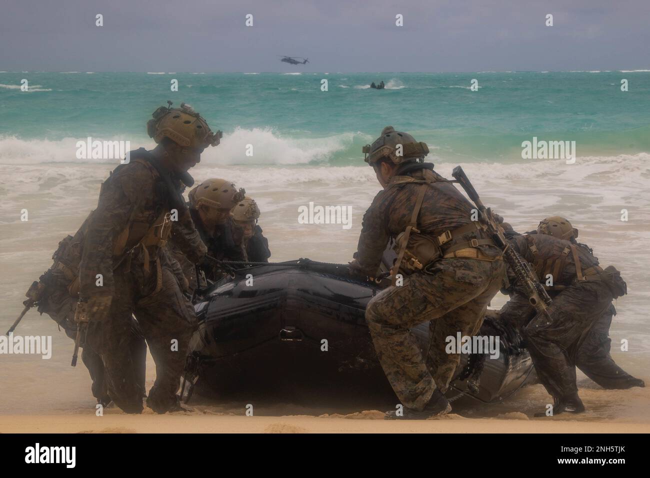 MARINE CORPS TRAINING AREA BELLOWS, Hawaii (July 18, 2022) U.S. Marines with 3rd Reconnaissance Battalion, 3rd Marine Division and Australian Army Soldiers pull a combat rubber raiding craft onto the beach for helo-cast training during Rim of the Pacific (RIMPAC) 2022, at Marine Corps Training Area Bellows, Hawaii, July 18. Twenty-six nations, 38 ships, four submarines, more than 170 aircraft and 25,000 personnel are participating in RIMPAC from June 29 to Aug. 4 in and around the Hawaiian Islands and Southern California. The world's largest international maritime exercise, RIMPAC provides a u Stock Photo