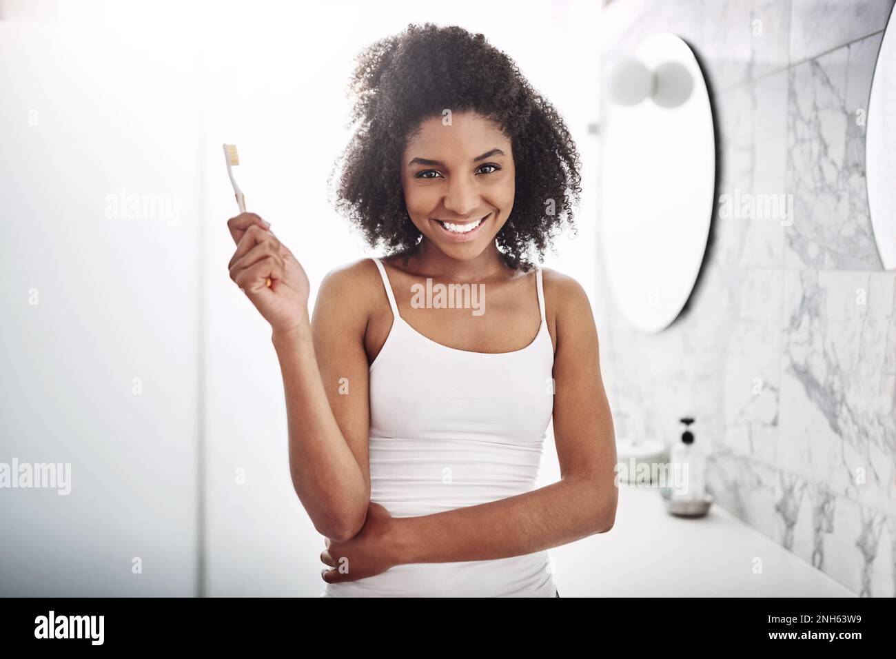 Im a certified smile keeper. Portrait of an attractive young woman brushing her teeth in the bathroom at home. Stock Photo