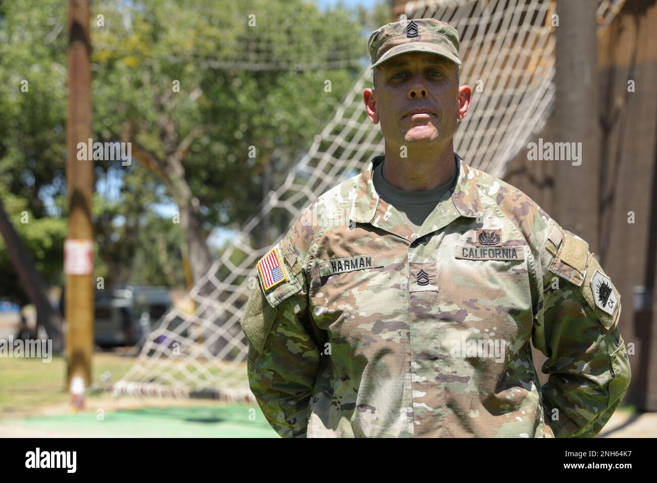 California State Guard Sgt. 1st Class Justin Harman stands in front of a rope course at Orange
