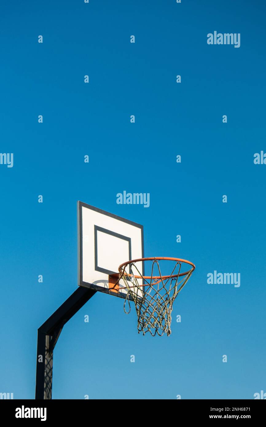 Street basketball hoop on background of vibrant sky. Creative minimalistic photo. Street Basketball Loop Basket Outdoors Abstract sport wide blank empty background texture, copy space. Sports, leisure activities creative bright backgrounds concept Stock Photo