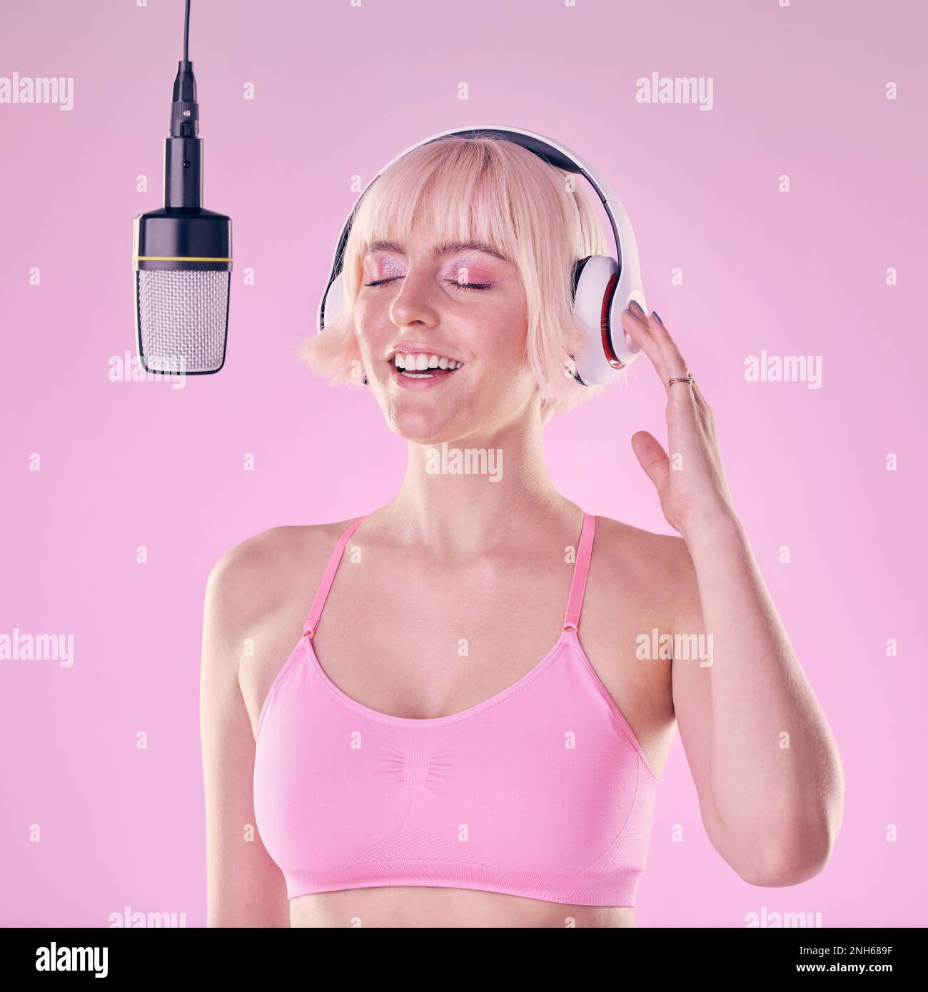 Headphones, microphone and woman singer in a studio recording a song