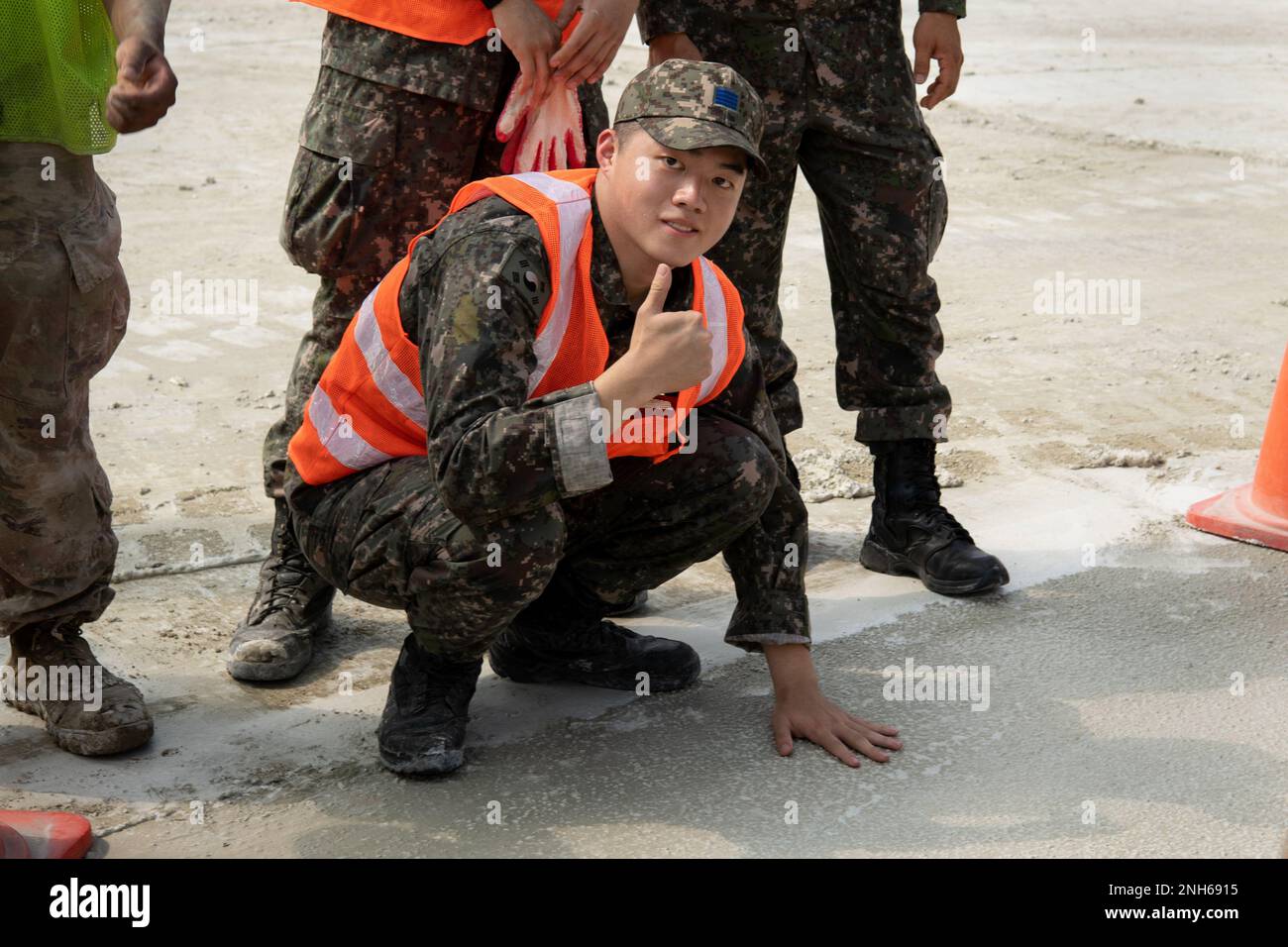 A member of the Republic of Korea Air Force (ROKAF) feels the finished product of a recently repaired cement pad during rapid airfield damage repair training, July 19, 2022 at Gwangju Air Base, Republic of Korea. During the combined training, members from the ROKAF and U.S. Air Force worked together to repair a damaged cement training pad and had the opportunity to strengthen their interoperability. Stock Photo