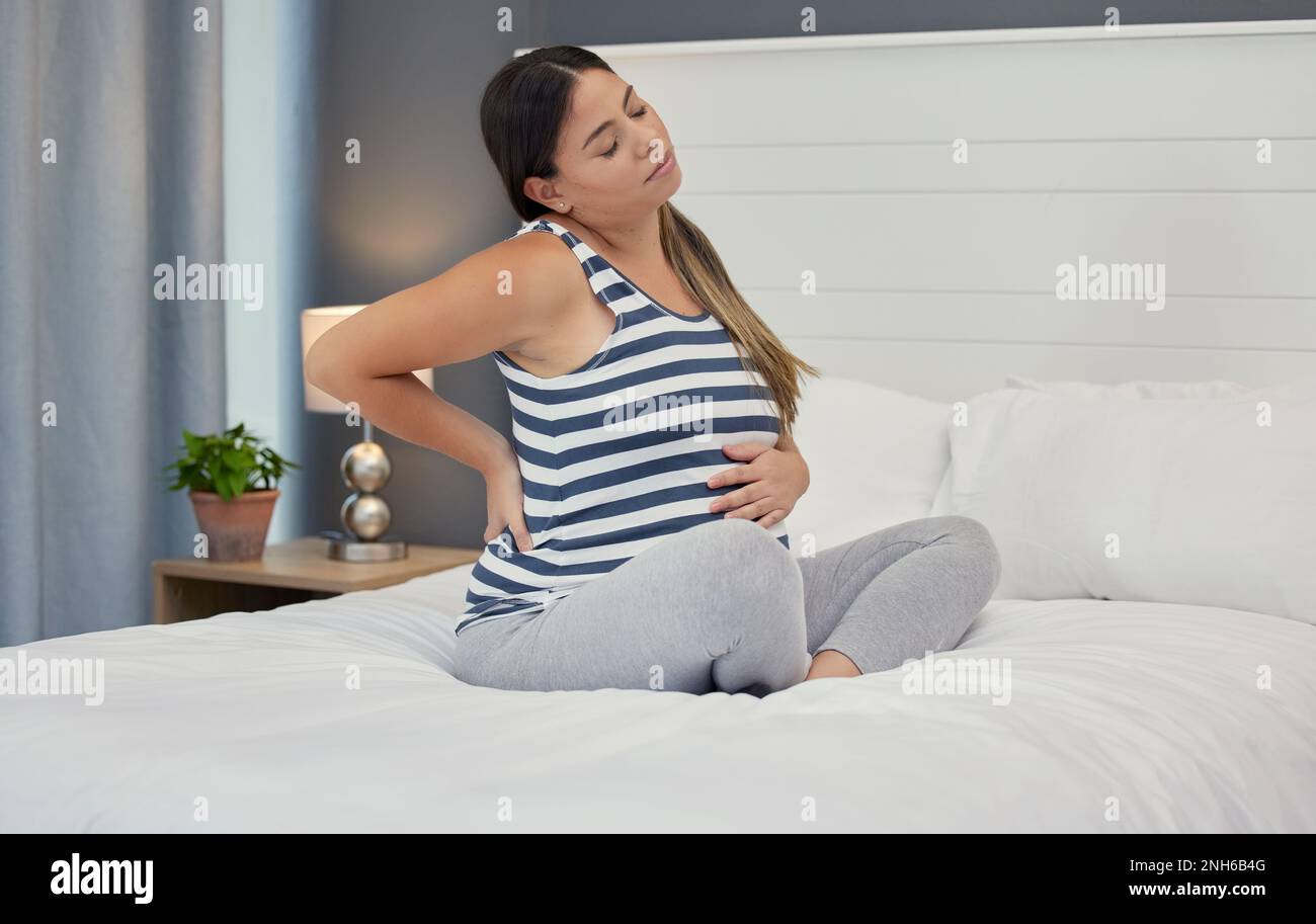 Pregnant, bed and woman with back pain, maternity issues and anxiety