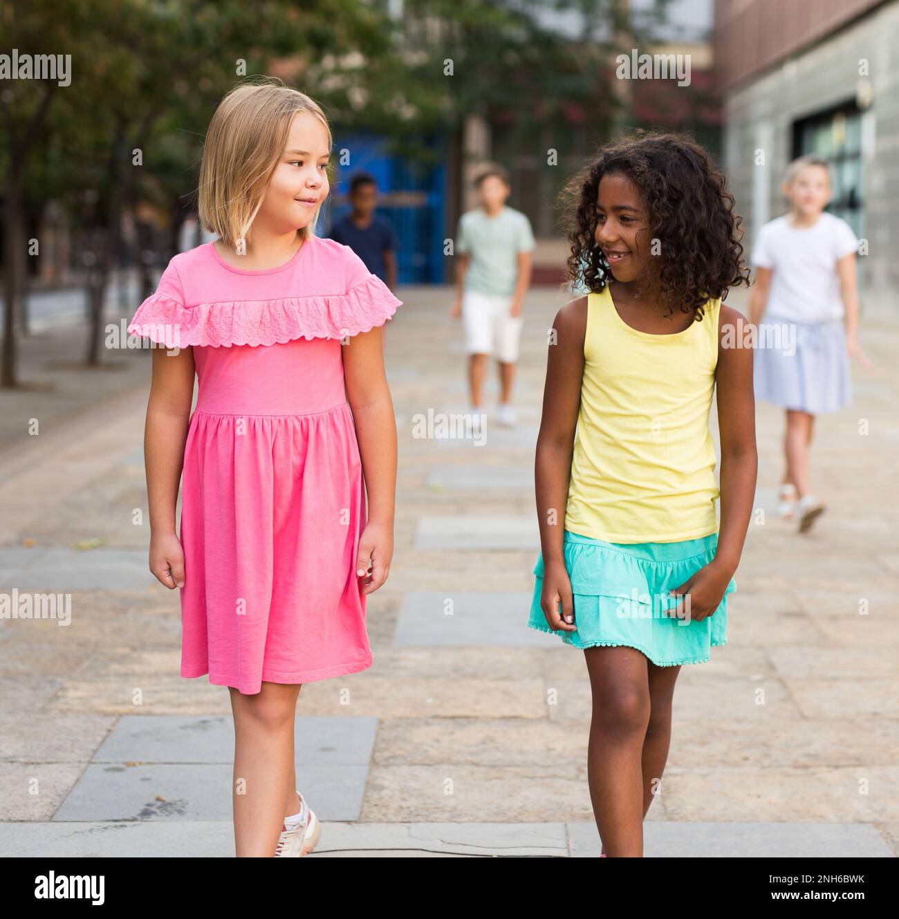 Two girls walking together outdoors Stock Photo - Alamy