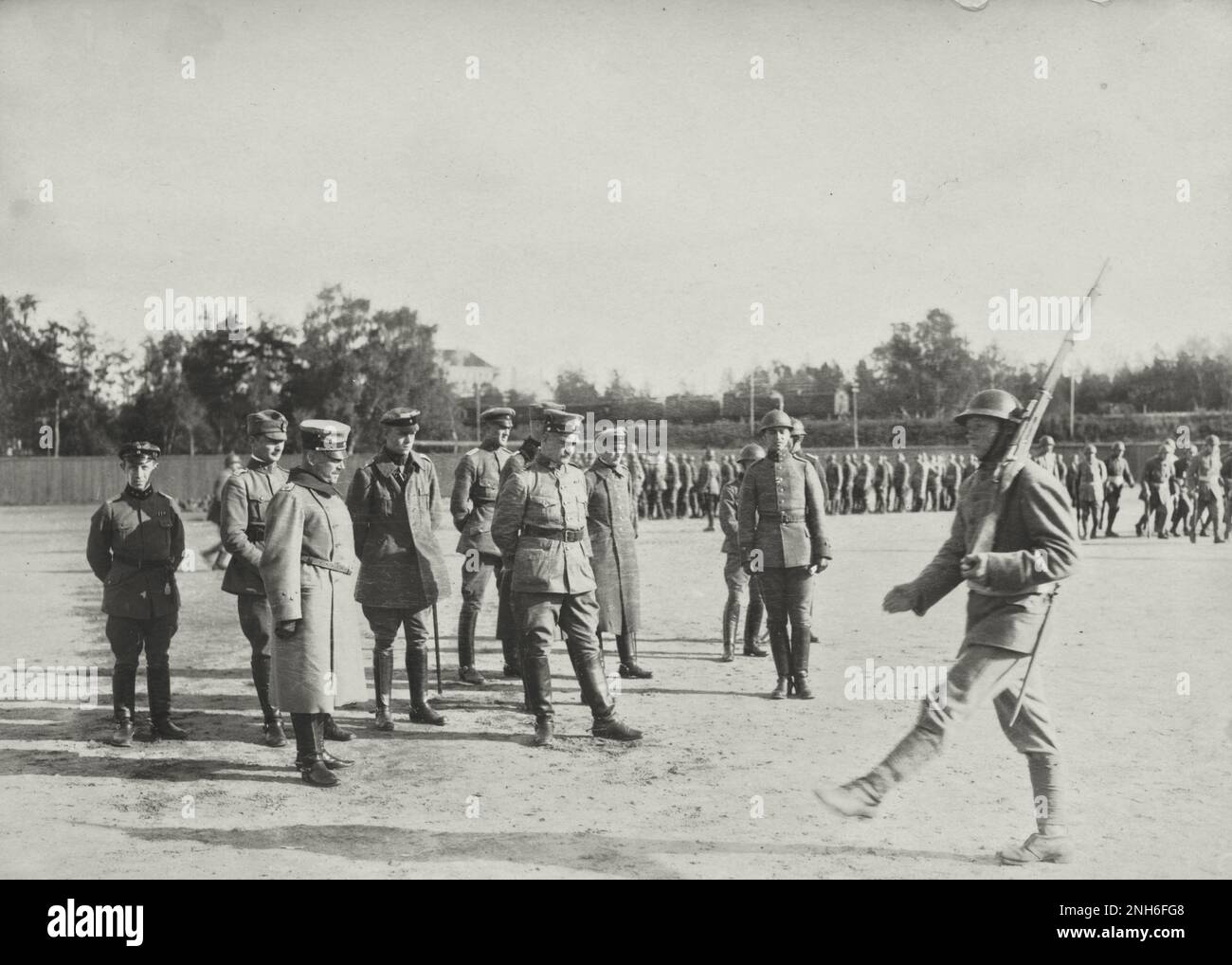 1914-1918. World War I. Polish soldiers (?) with a rifle on his shoulder marching past a group of officers. Stock Photo