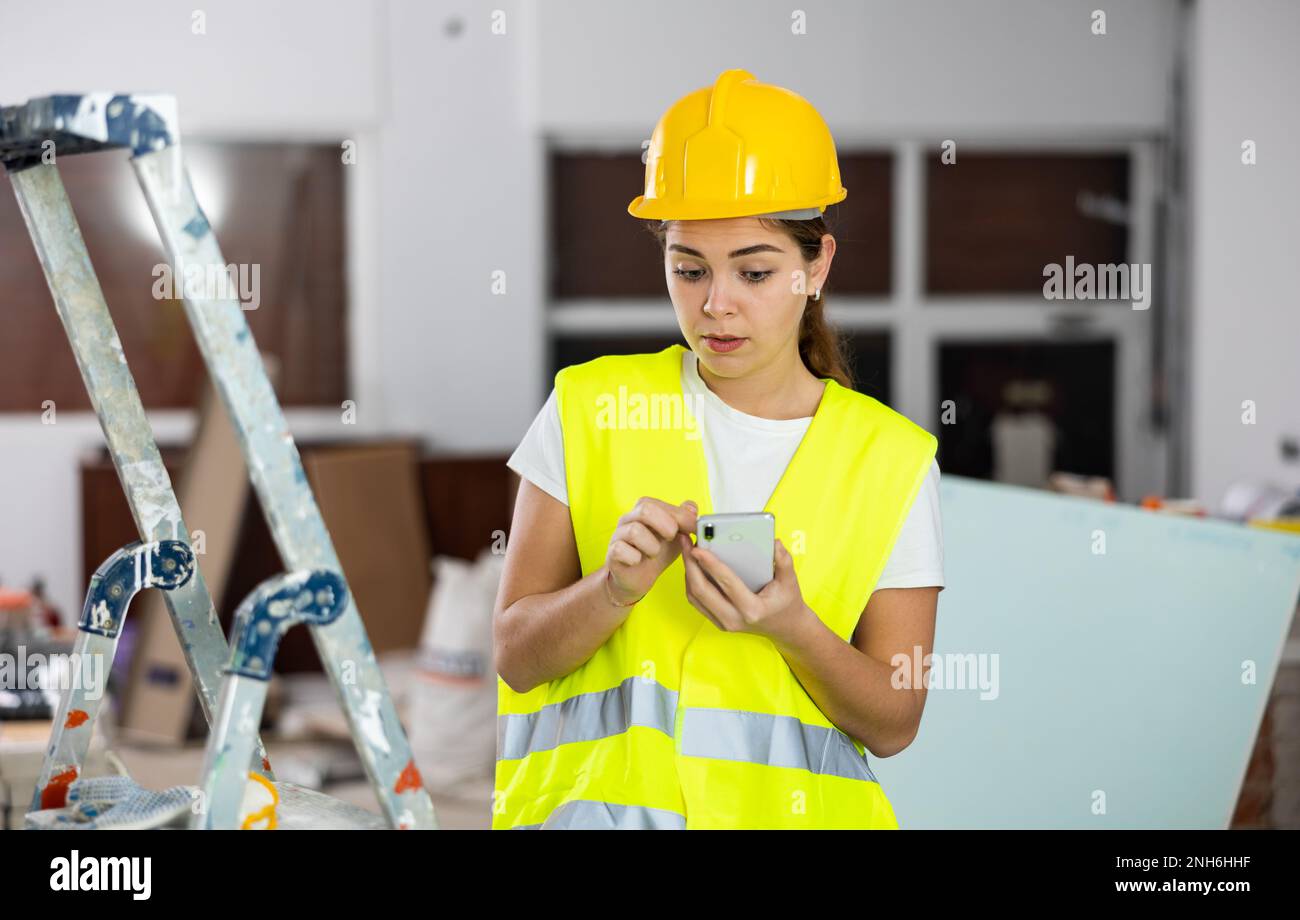 Young woman engineer using smartphone in construction site Stock Photo