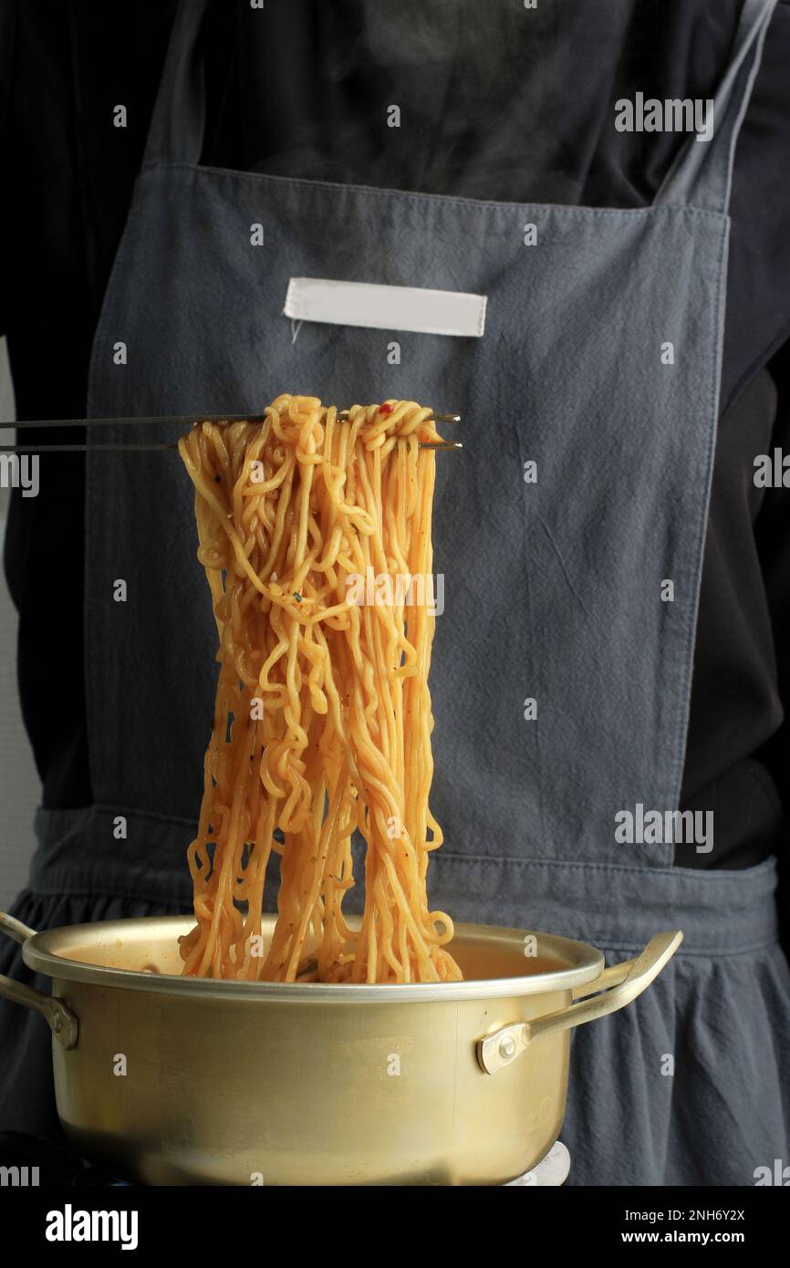 Female using Stainless Tongs to Cook Ramyeon or Korean Instant Noodles