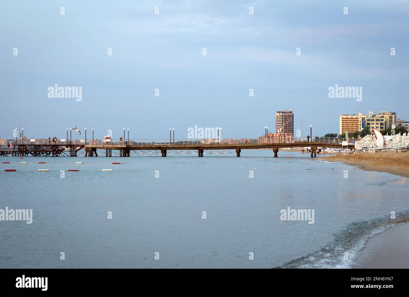 SUNNY BEACH, BULGARIA - JUNE 25, 2015: Landscape, a very early morning, empty seashore that seamlessly crosses the pier going into the sea, against  b Stock Photo