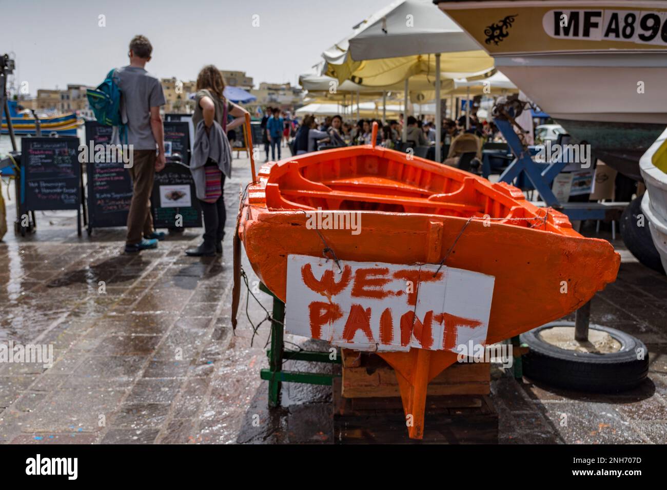 Freshly painted boat with wet paint sign in Marsaxlokk seafront, Malta Stock Photo