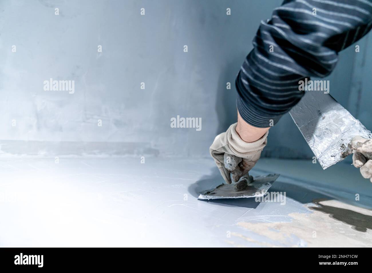 work with trowel on floor and wall in new room in building Stock Photo ...
