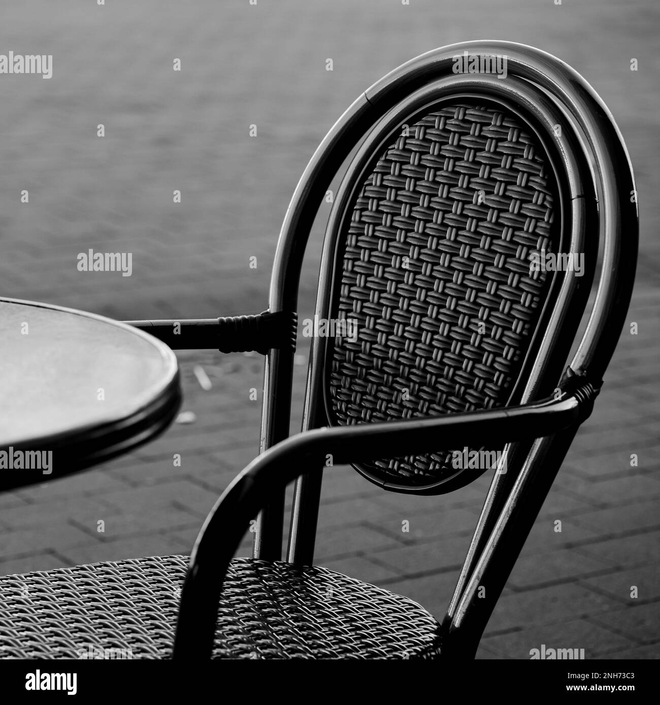 Square Format Black And White Or Monochrome Image Of A Table And Chair Outside Seating Area With No People Stock Photo