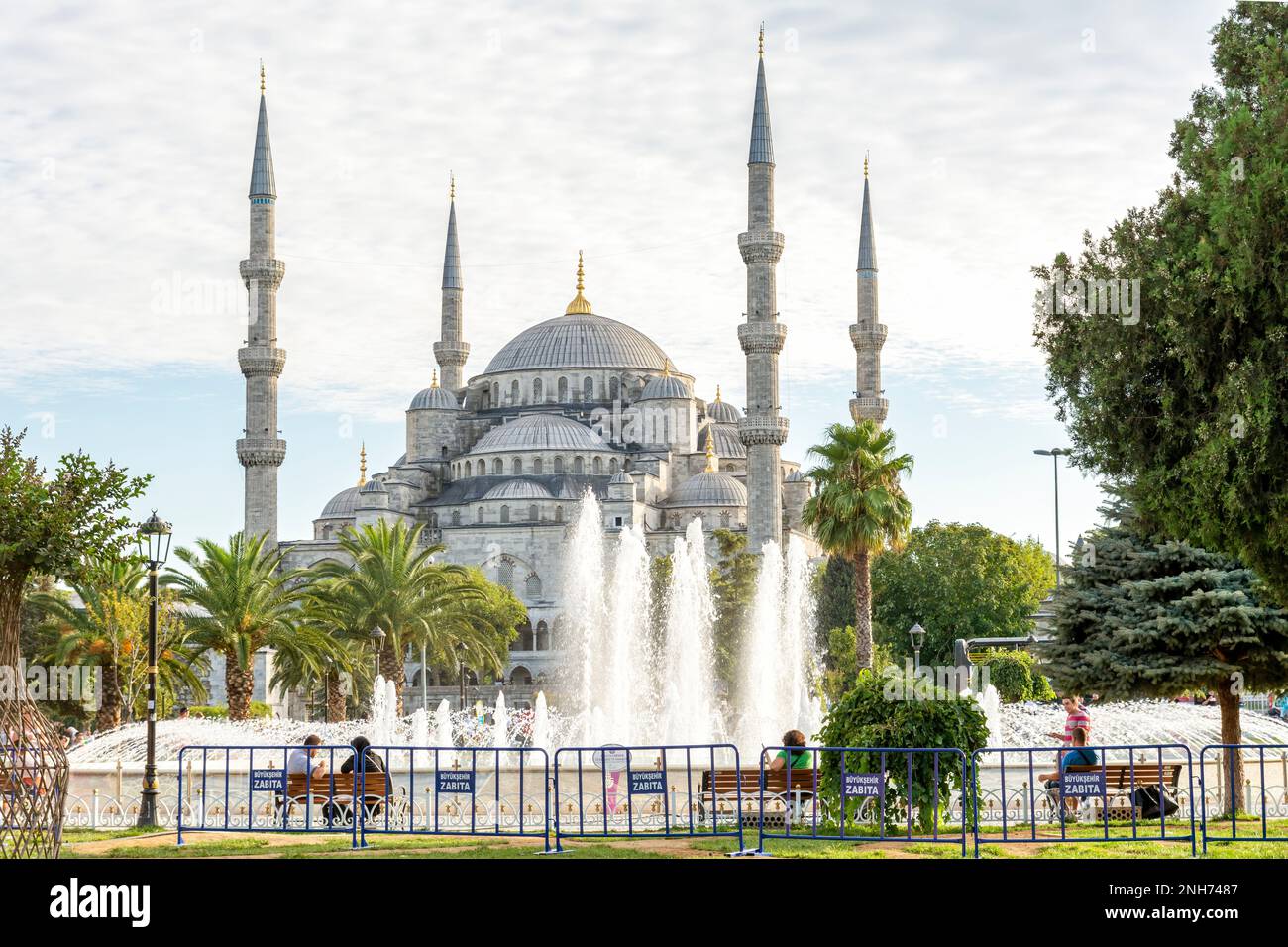 People sitting around the fountain at Sultanahmet Square, Sultan Ahmet Mosque can be seen at the background. Istanbul, Turkey (2013) Stock Photo