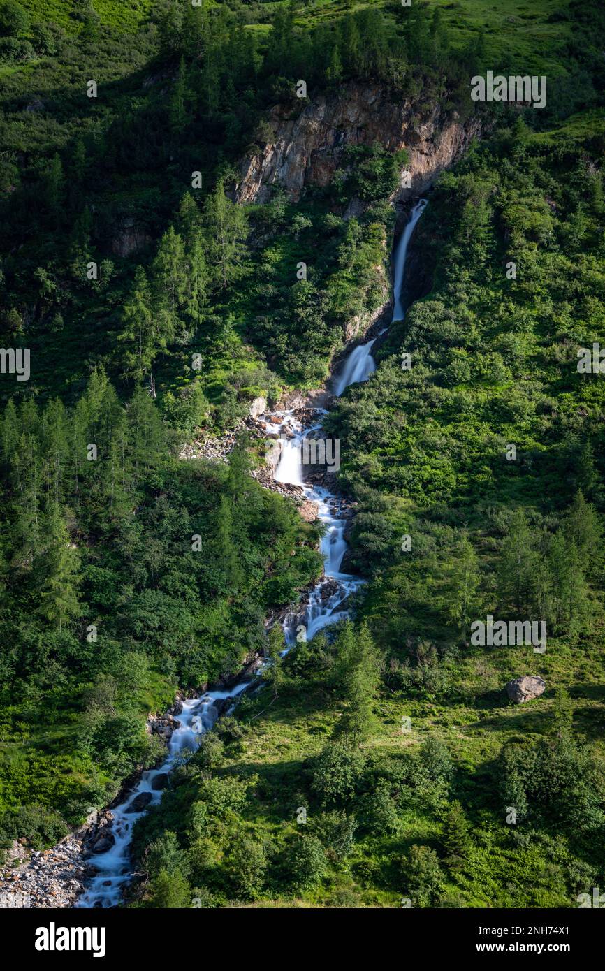 A waterfall running down the mountain Stock Photo - Alamy