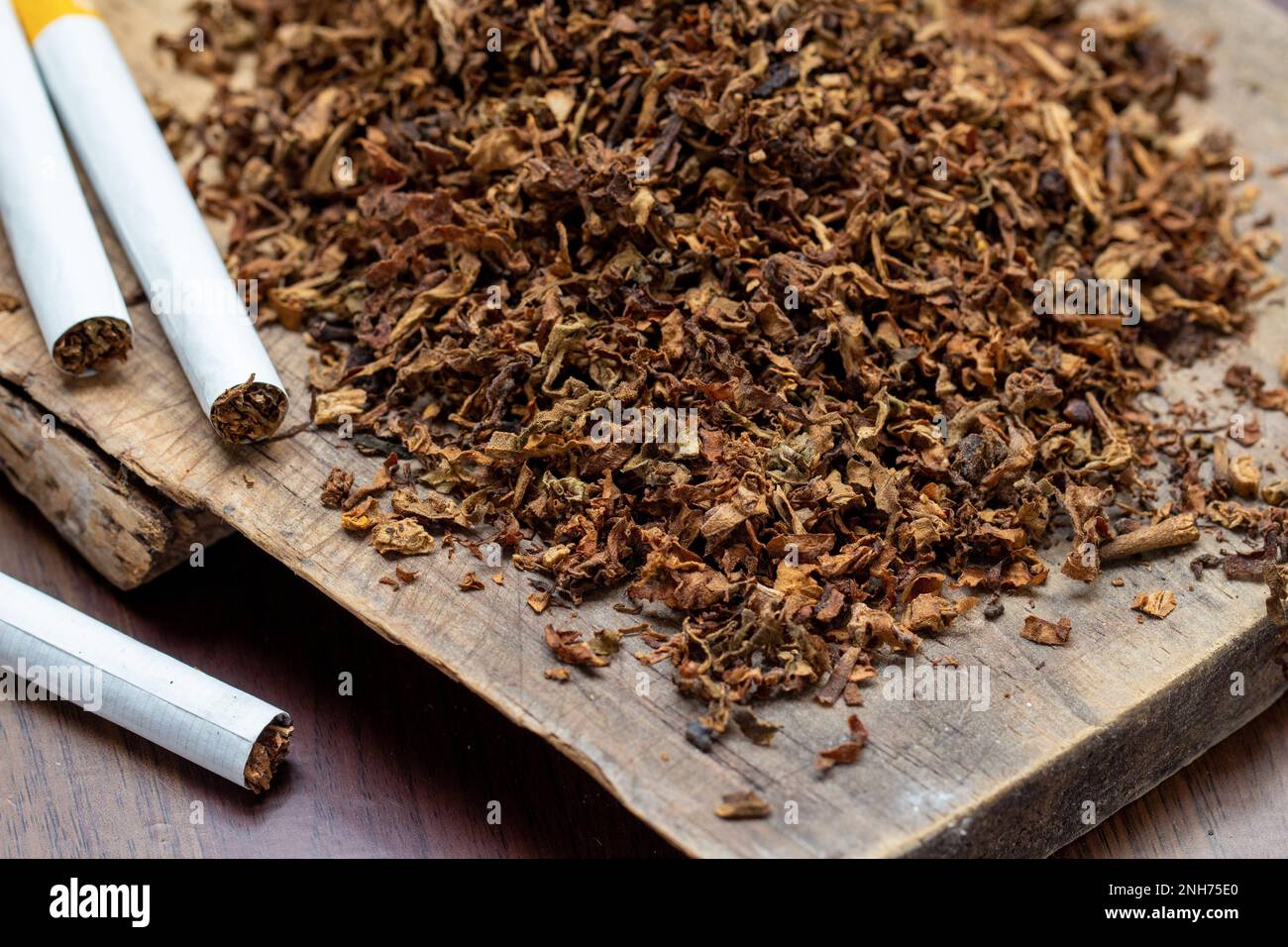handmade cigarettes tobacco leaves and handmade cigarettes on a wooden background Stock Photo